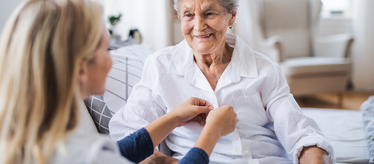 staff-helping-an-elderly-person-dress